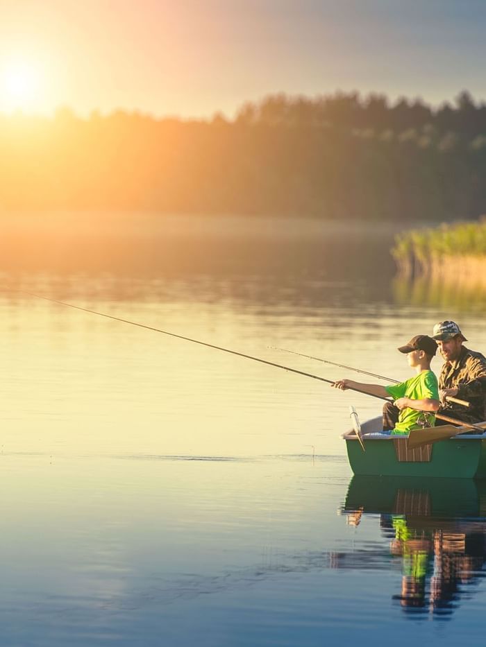 Father & son fishing from a boat at sunset near WaterColor Inn