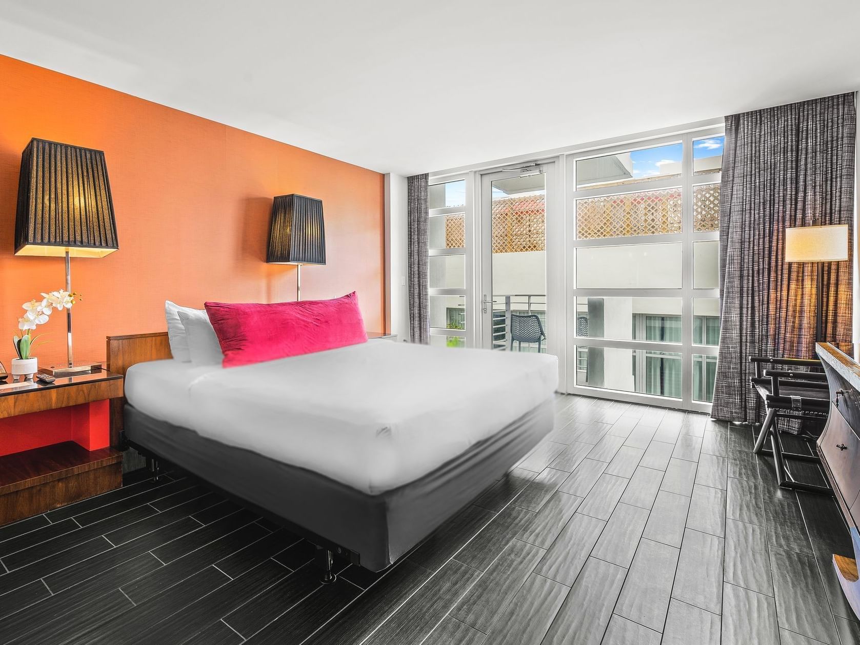 King bed with nightstands by the balcony window in Deluxe King with Balcony at Fairwind Hotel Miami