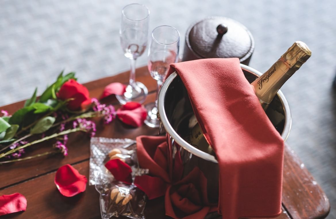 Champagne bottle served with glasses on a table with rose deco at Blackcomb Springs Suites