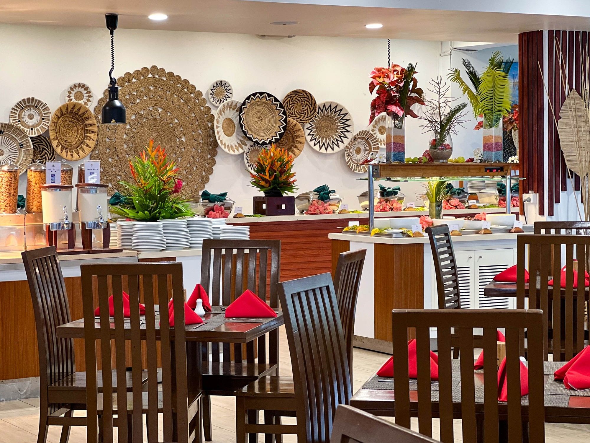 Tables with wooden chairs and red napkins in a restaurant at Naviti Resort Fiji Coral Coast كورال كوست