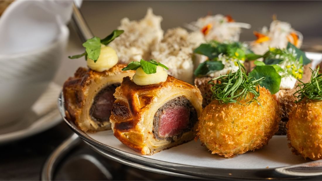 Tempting beef wellington pastries and crispy arancini served on a tiered stand at Sunway Resort