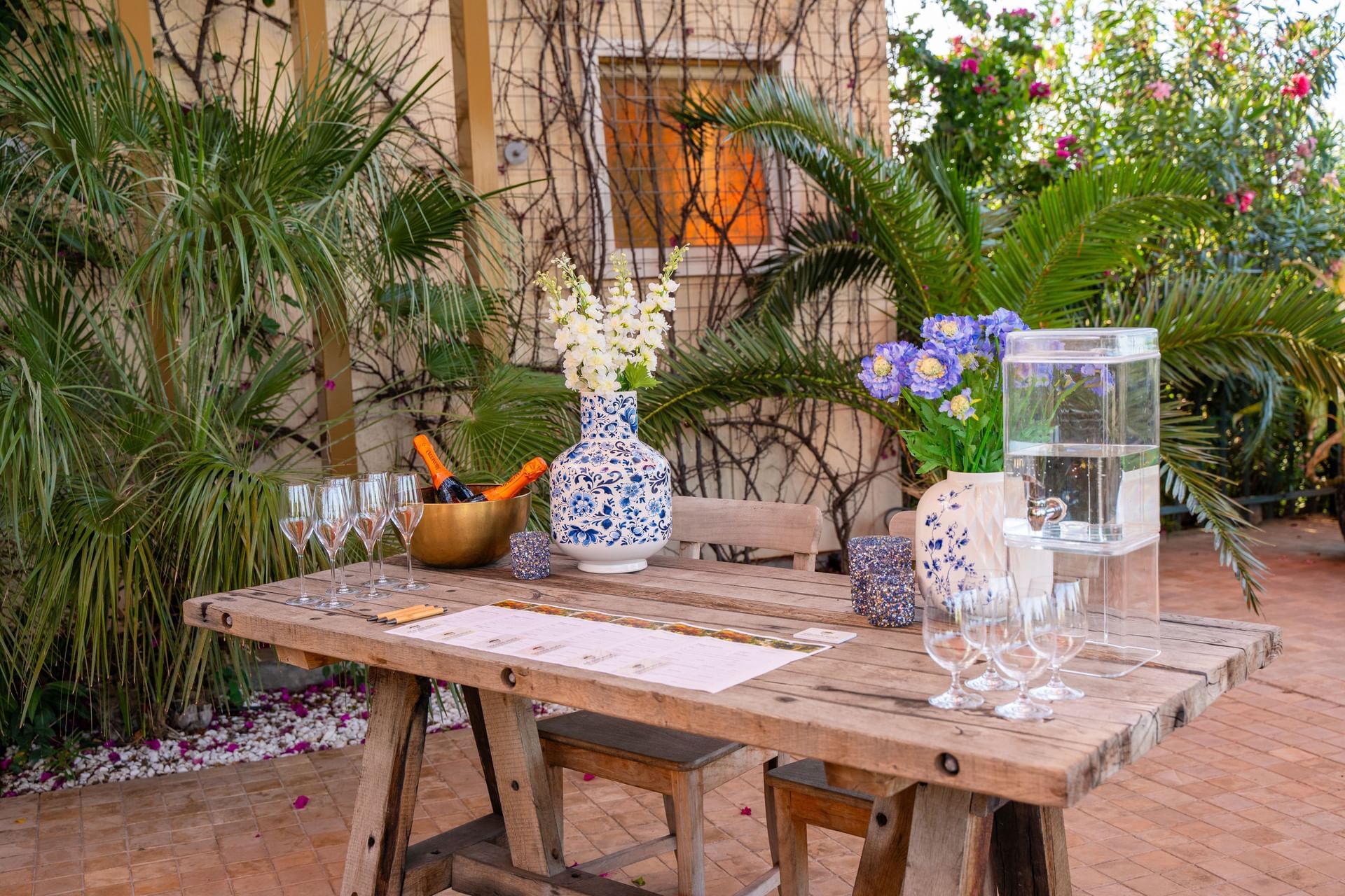 Rustieke tafel met champagnefluiten en bloemen te midden van groen in de MICE-faciliteiten bij Golden Rock Resort