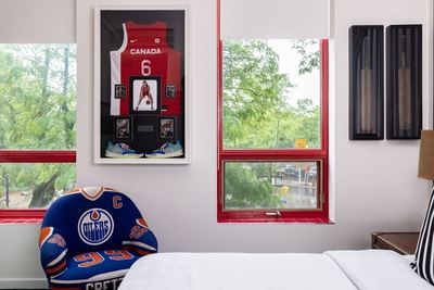 Queen Premiere with cozy bed, stylish chair, & a captivating painting on the wall at Retro Suites Hotel