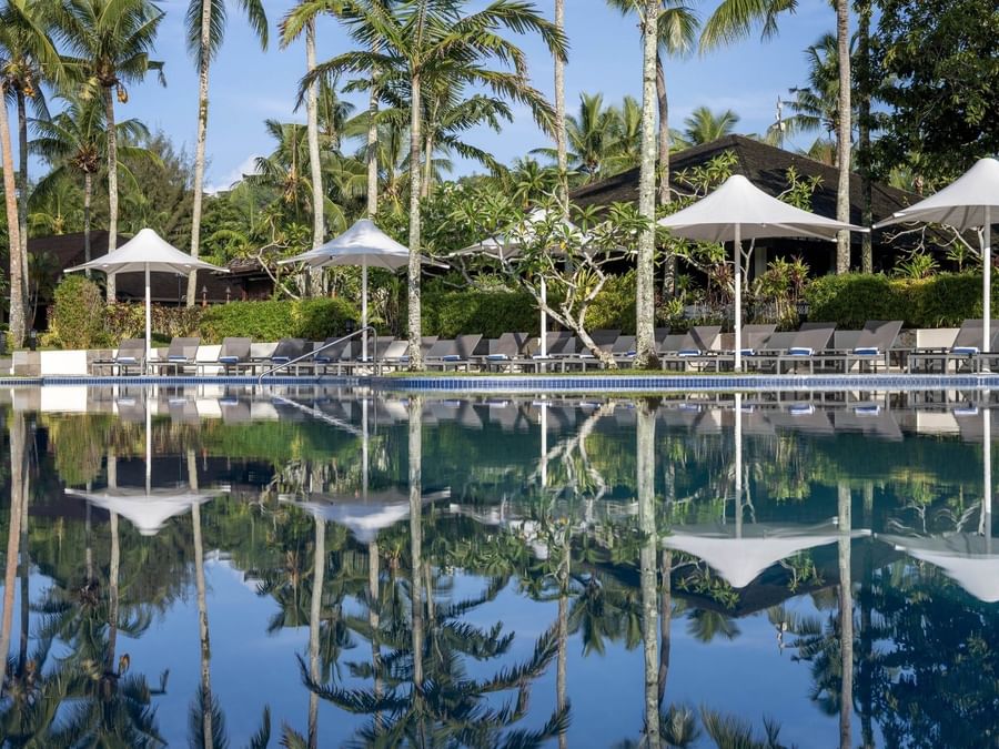 Tropical pool and terrace beach area with loungers under umbrellas at Warwick Le Lagon in Efate