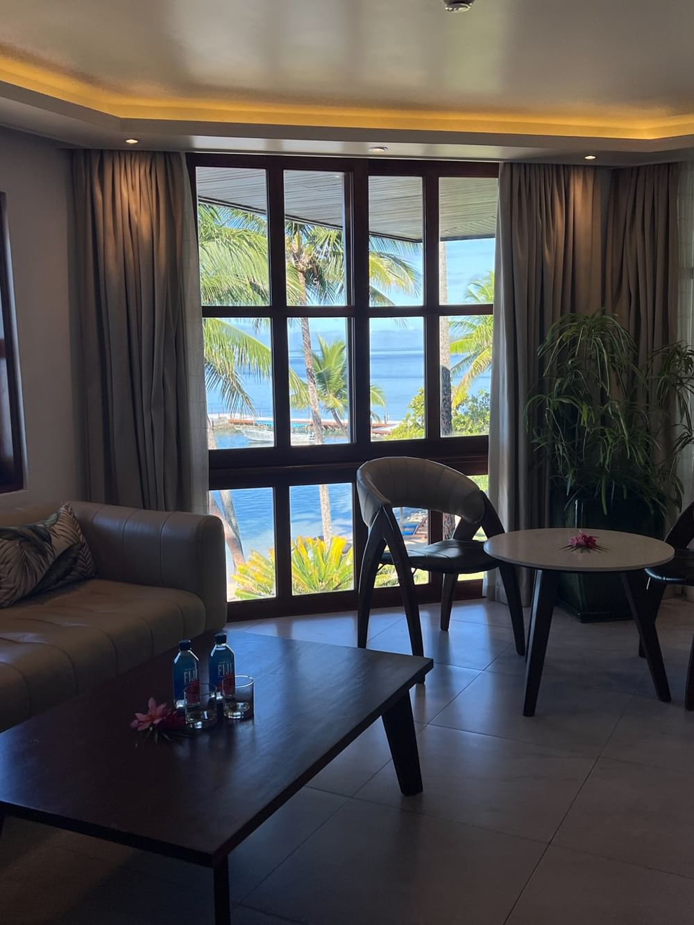 Suite with couch, table, chairs, and ocean view at Warwick Fiji Resort and Spa in Korolevu.