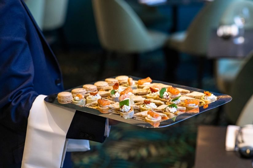 Waiter carrying tray of appetizers at Oceania Paris Roissy CDG