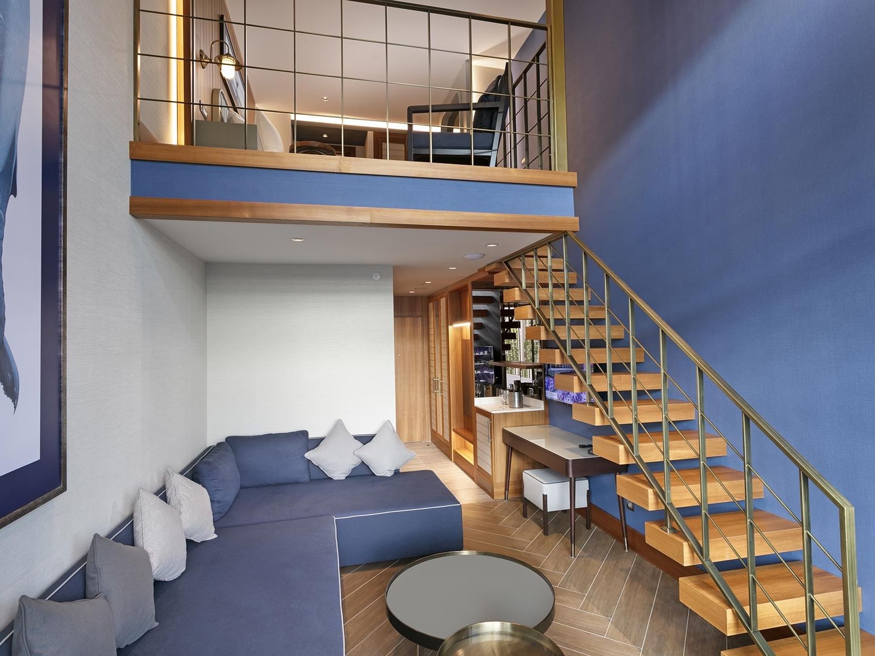 Cozy loungers in the living area and the stairs to the balcony in Duplex Suite at Titanic Deluxe Lara