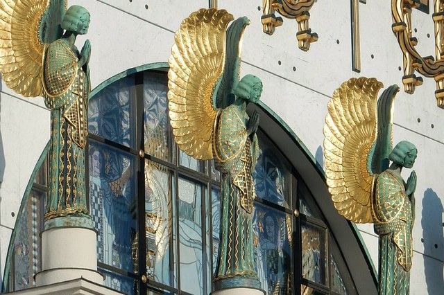 Gilded angel sculptures on the façade of Vienna’s Church am Steinhof featuring intricate Art Nouveau details and colorful stained glass windows