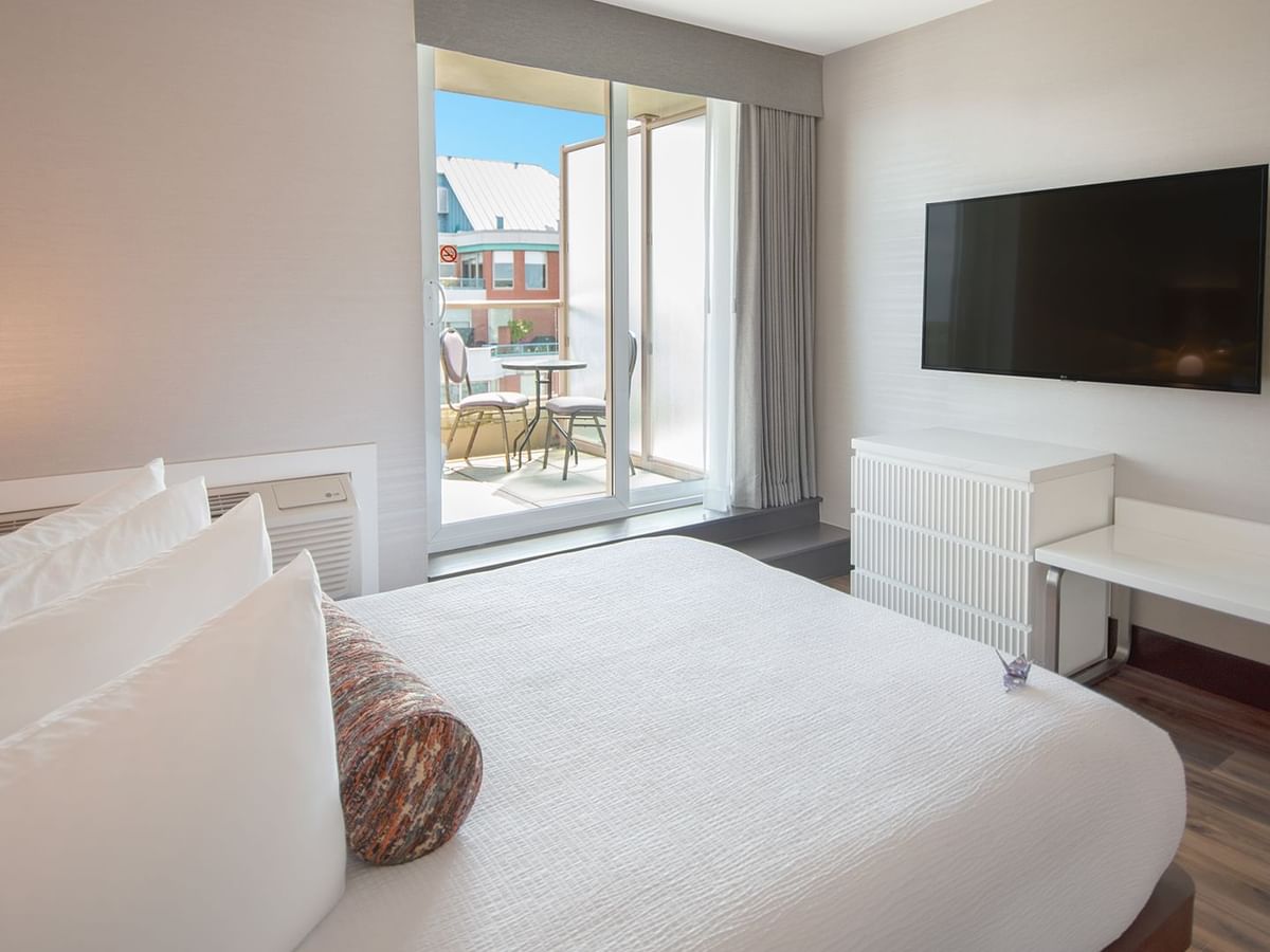 Hotel guestroom with a queen size bed and TV