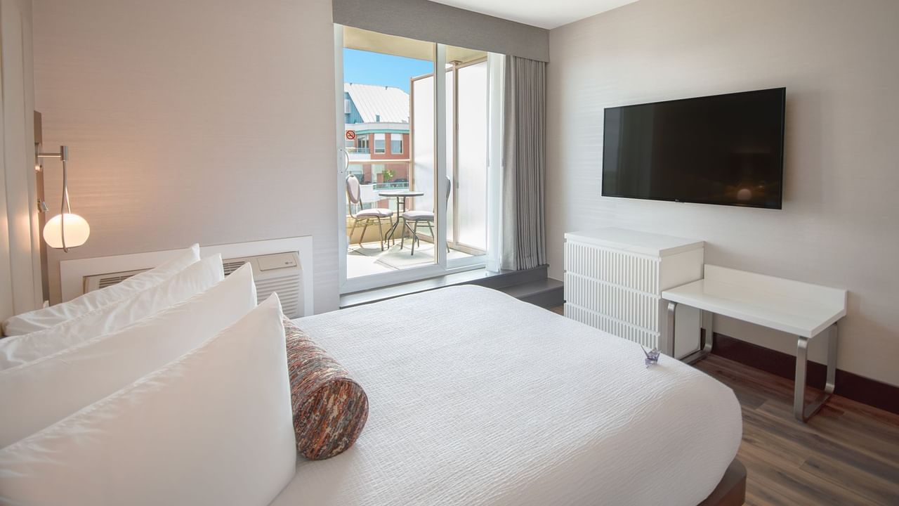 Hotel guestroom with a queen size bed and TV