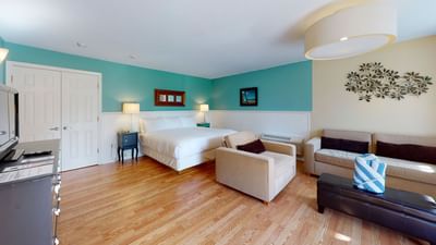 TV lounge by the bed and wooden floors in Main Building Studio at Breezeway Boutique Hotel