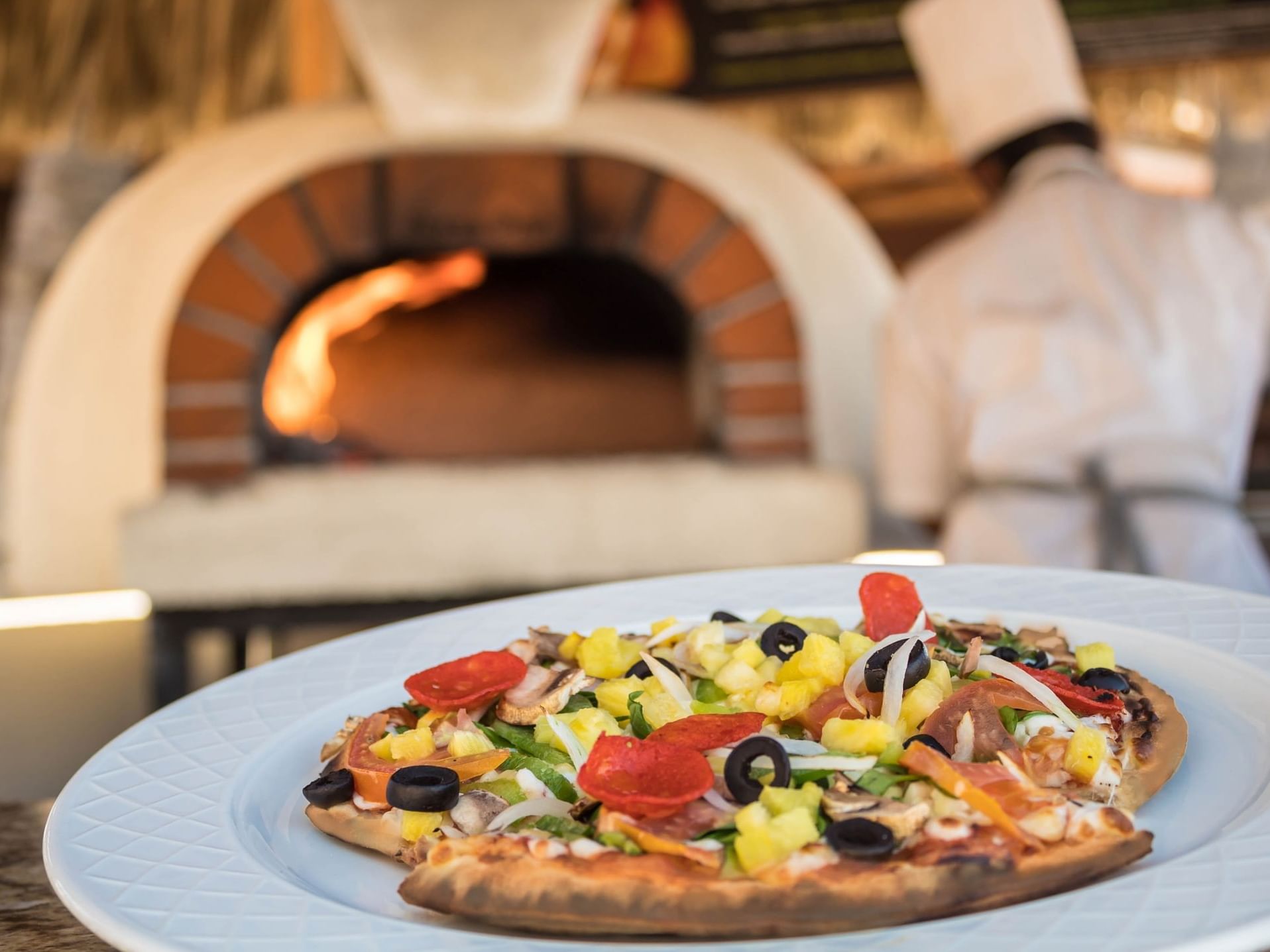 Close-up of a pizza served in Pizzeria at Plaza Pelicanos Grand Beach Resort