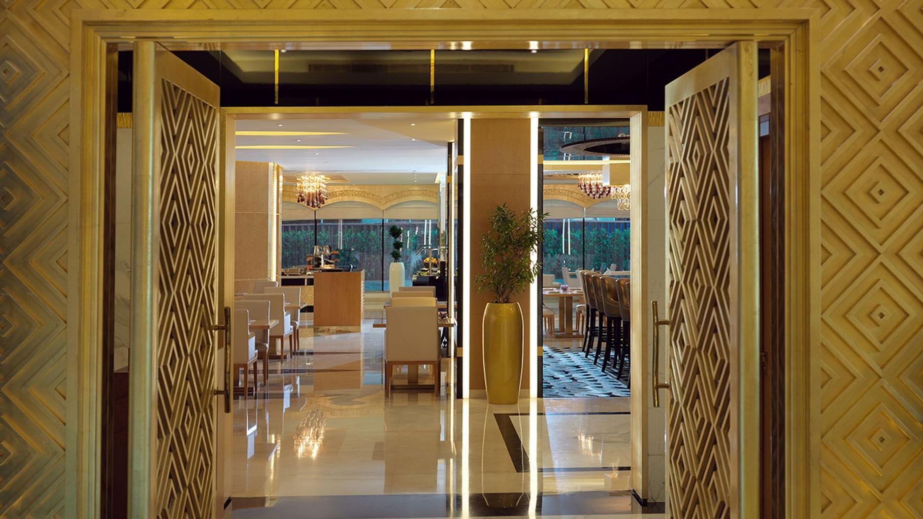 Entrance to luxurious restaurant with chandeliers hanging above a dining area at DAMAC Maison Dubai Mall Street