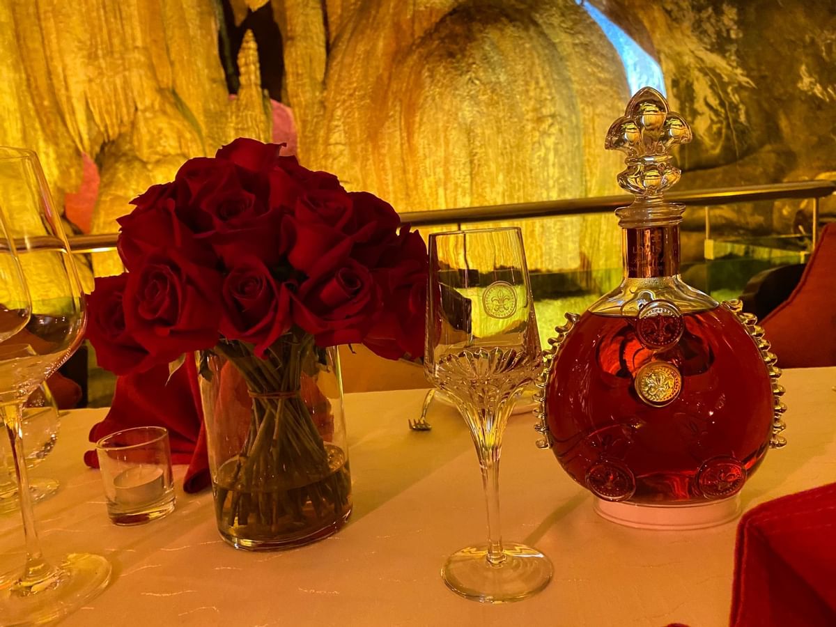 Close-up of roses & liquor beverages on a table served at The Banjaran Hotsprings Retreat