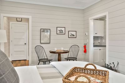 Deluxe King Cottage with plush bed, wooden floors, mini dining table, and bathroom view by Cottages at Laurel Brooke