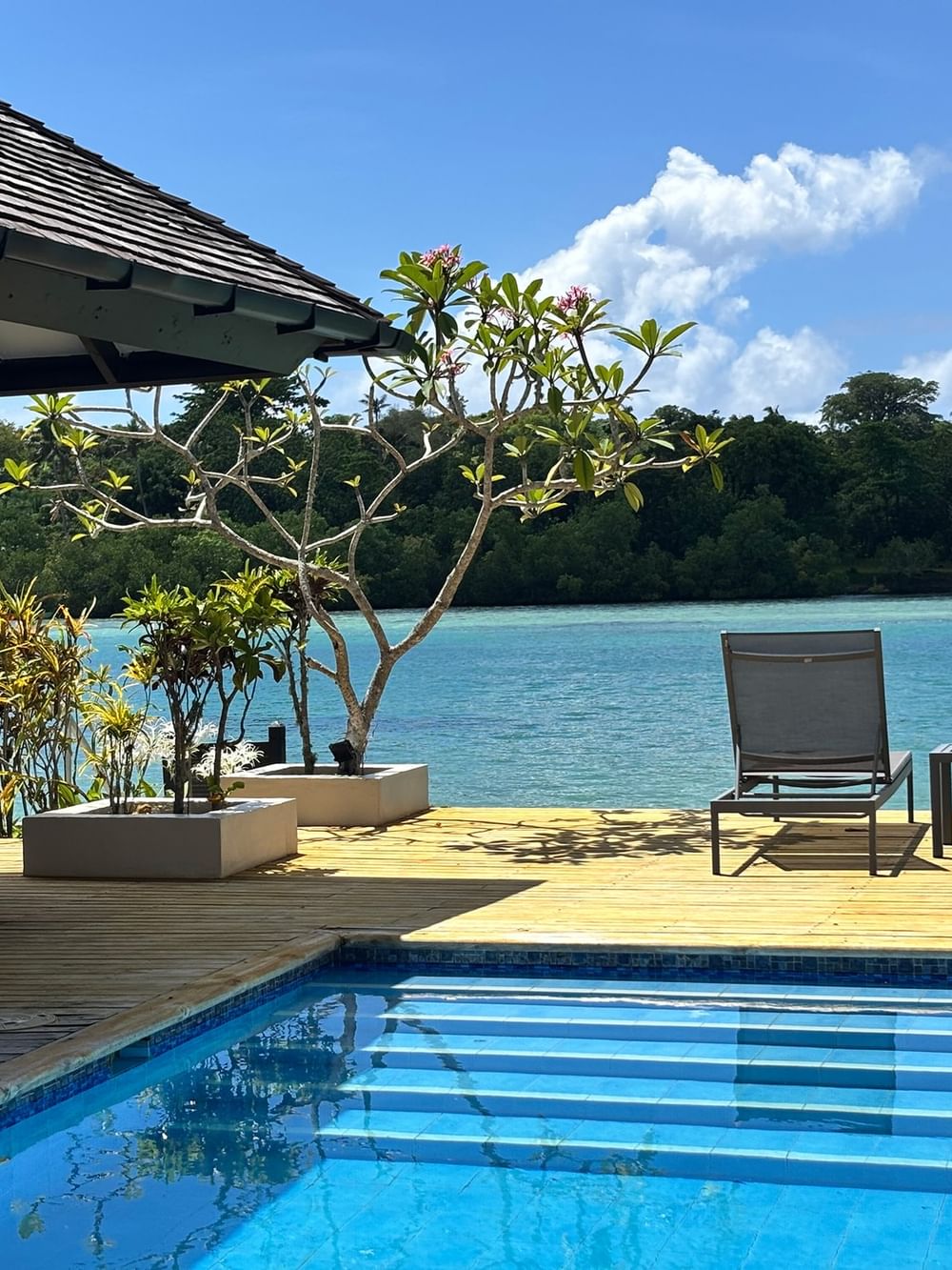 Wooden deck with pool and ocean view at Warwick Le Lagon Vanuatu in Efate.