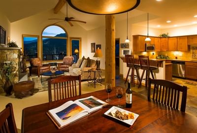 A rustic yet luxurious guest suite interior at The Stanley Hotel featuring an open-plan living and kitchen area