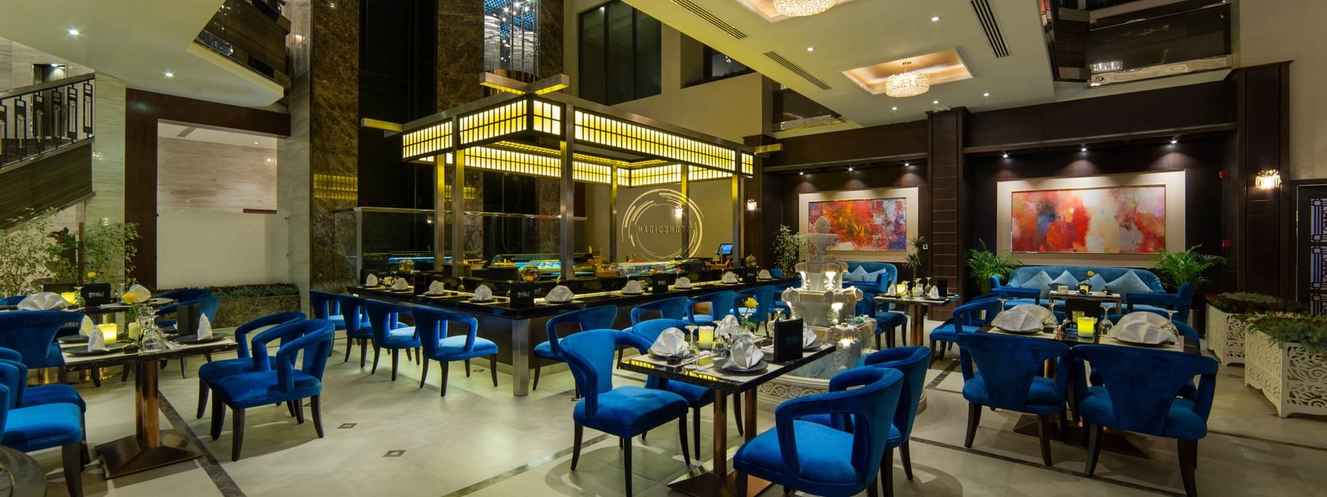 Taki Restaurant featuring bright blue velvet chairs and white tablecloths at Warwick Al Khobar