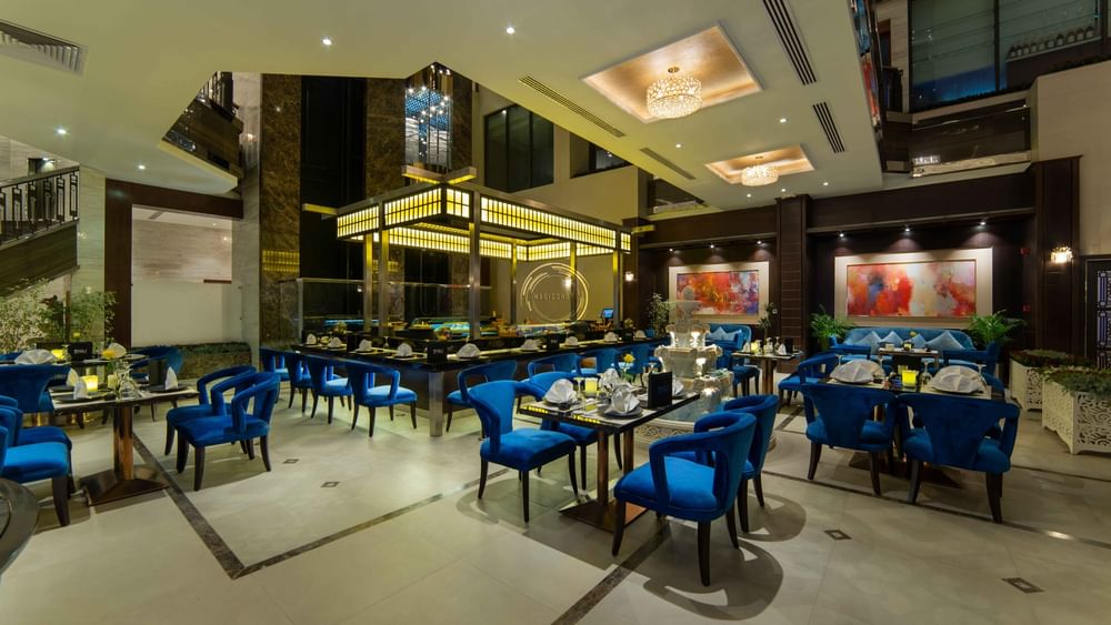 Taki Restaurant featuring bright blue velvet chairs and white tablecloths at Warwick Al Khobar