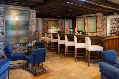 Cozy bar with wooden beams, and blue upholstered chairs at the inn at Willow grove