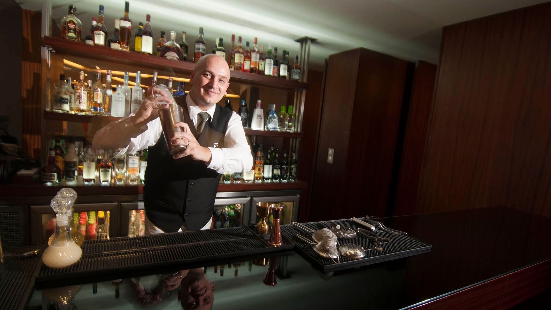 Bartender making a drink by the counter in The Gardener at Terra Nostra Garden Hotel