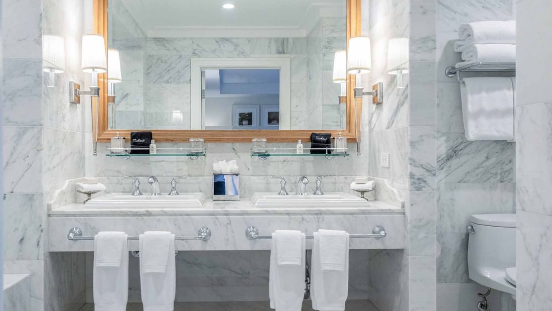 Double vanity, large mirror, and neatly folded towels in Penthouse bathroom at El Prado Hotel