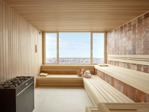 Salle de sauna avec grande fenêtre donnant sur un paysage urbain de la ville de Bruxelles