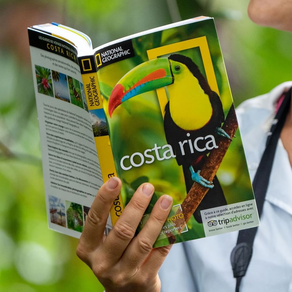 Lady reading a book about Toucans near Hideaway Rio Celeste