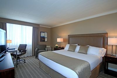 Bed with a work desk in Standard King room at Ethan Allen Hotel