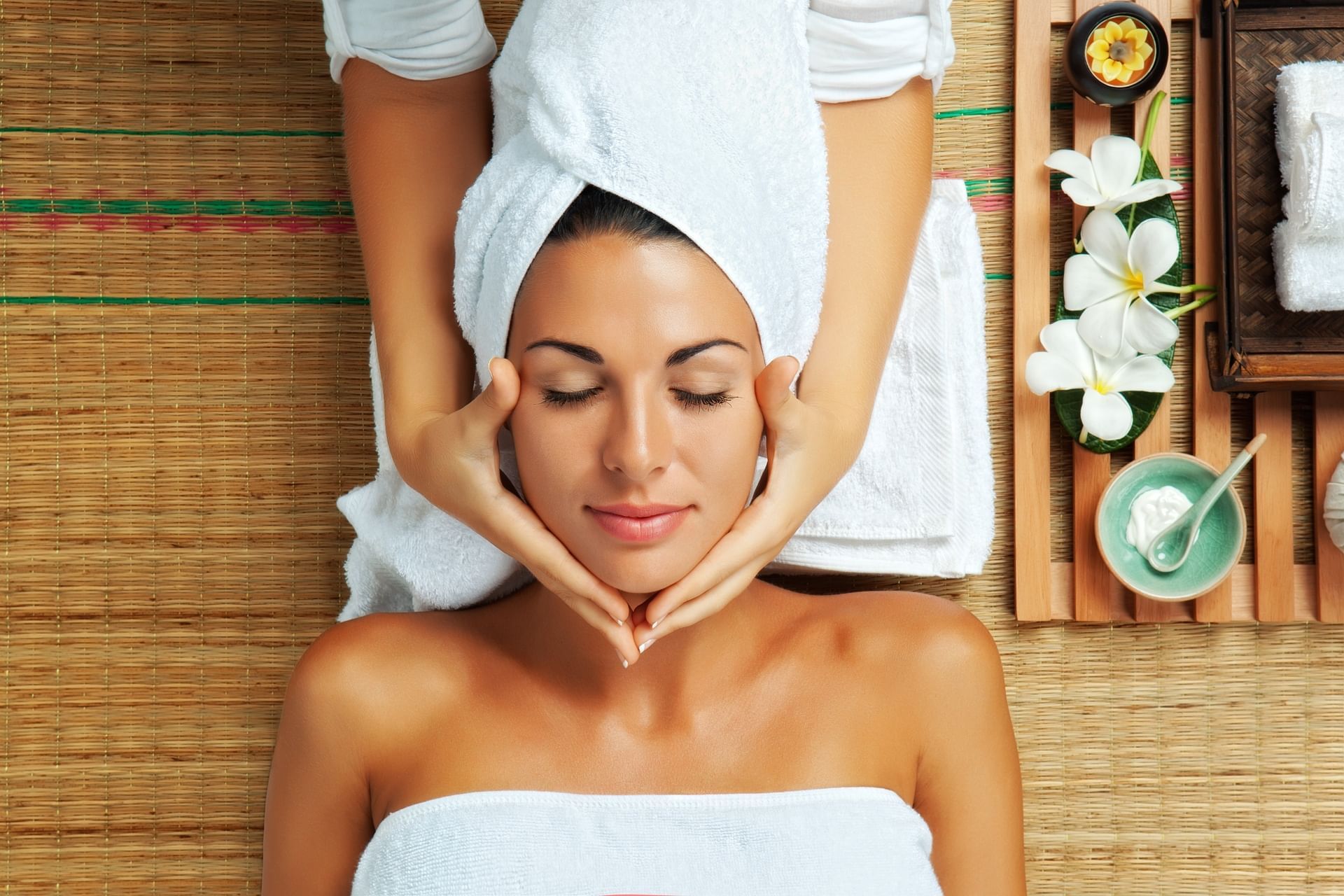 Woman in a spa wrapped in white towels for a soothing facial massage at the spa of El Conquistador Resort