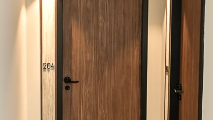 Couloir avec porte en bois numéro 204 de l'Hôtel Rivella.