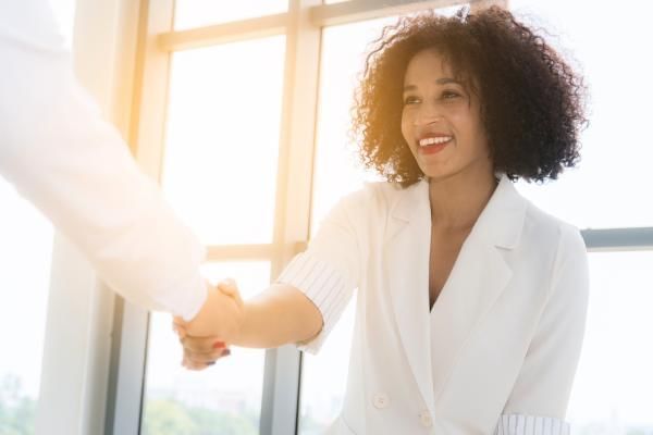 Happy employee shaking hands with boss, a higher job retention rate due to remote working