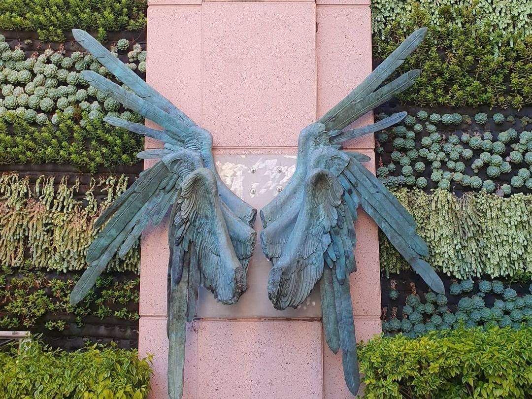 Angel wings décor hanging on a wall at Marquis Reforma