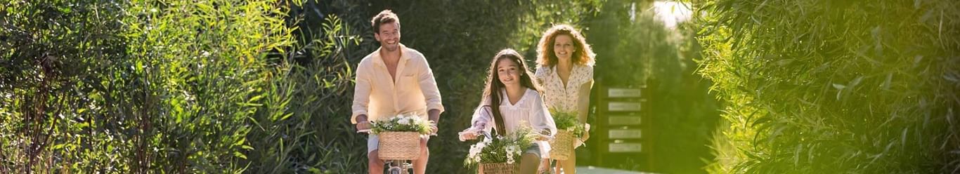 A family of three cycling in the pathway near Titanic Hotels