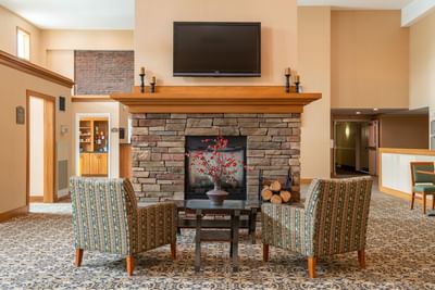 Cozy lounge area with a fireplace and TV at White River Inn and Suites, one of the top white river junction hotels