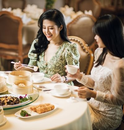 Two women enjoying a meal together at Hanoi Daewoo Hotel
