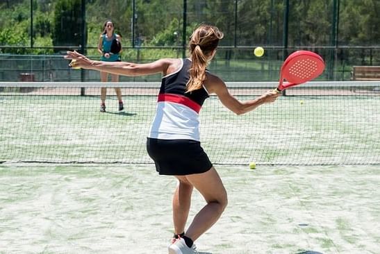 Dos señoras jugando tenis al aire libre en Live Aqua Resorts