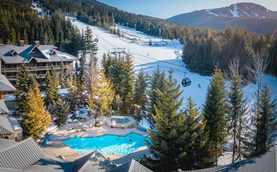 Aerial view of Blackcomb Springs Suites & snow-covered hill with zipline
