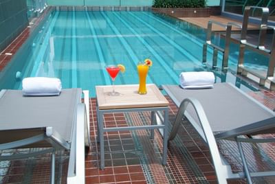 Two cocktails by the swimming pool  sunbeds at Amora Hotel