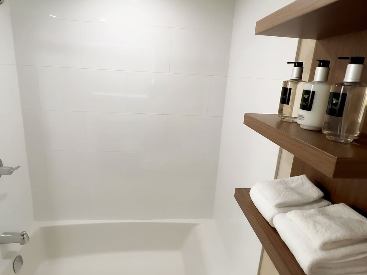 Bathroom with shower, wall cabinet with towels and bottles of liquid