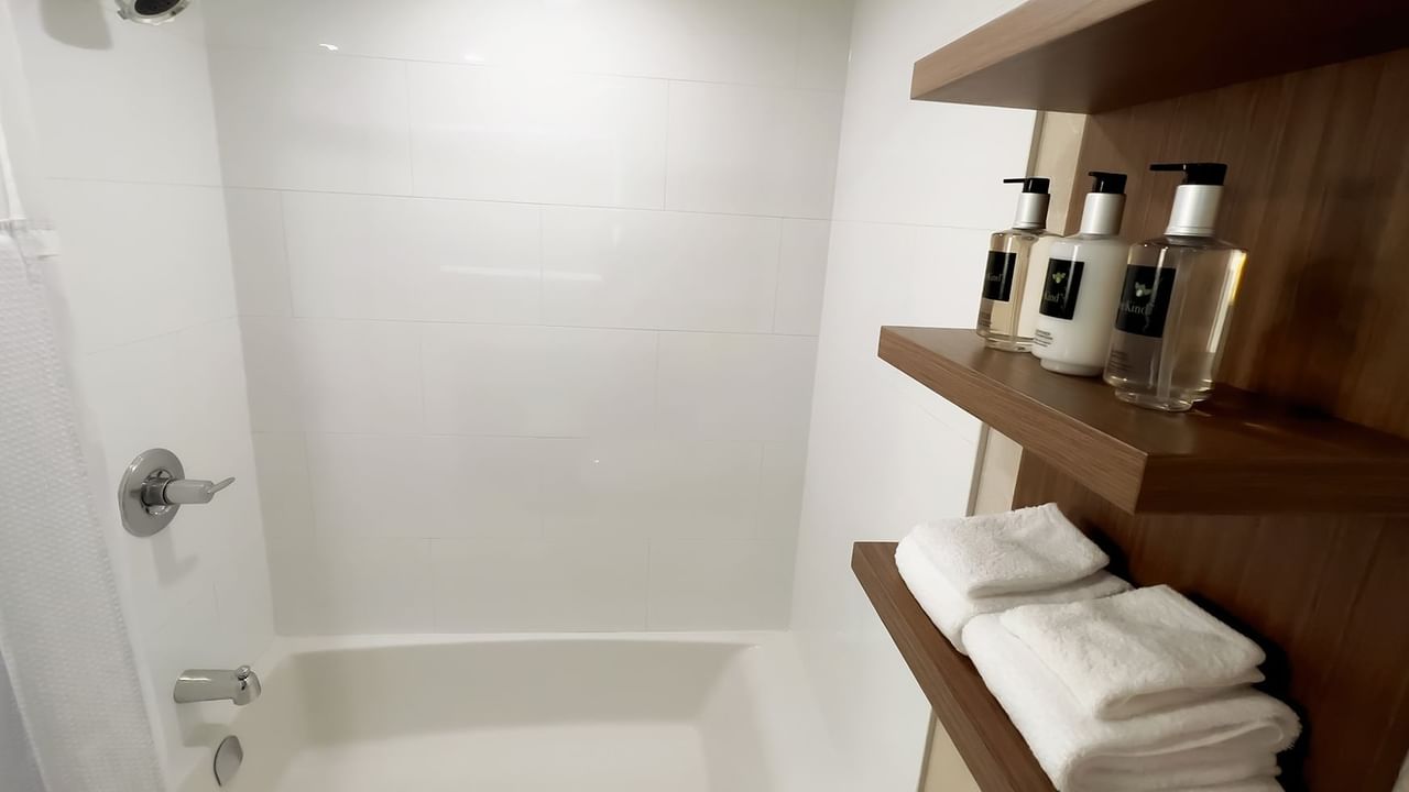 Bathroom with shower, wall cabinet with towels and bottles of liquid