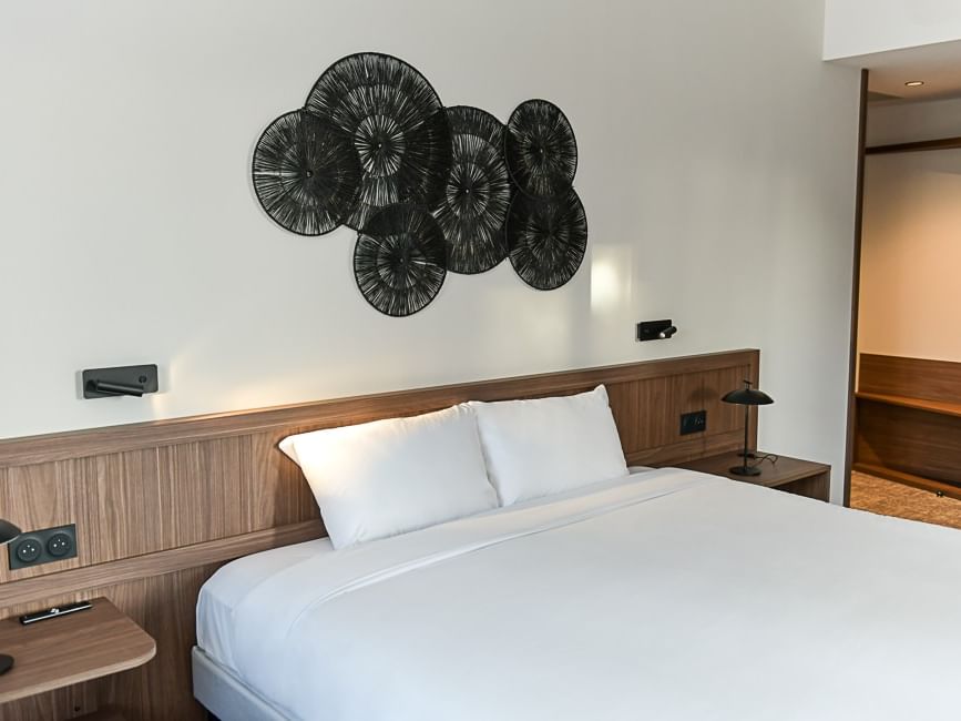 Chambre PMR élégante avec lit blanc et mur artistique au Hôtel Rivella, Clisson.