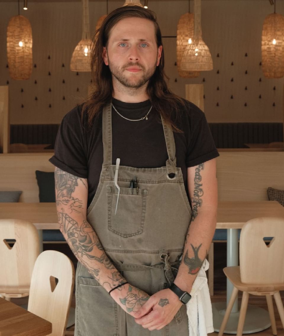 Photograph of hotel staff wearing an apron in a kitchen setting at The Stonebreaker Hotel