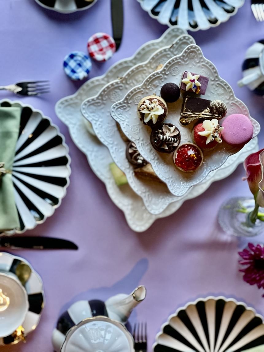Spring Tea table set with black and white dishes and a tiered dessert plate served at the Hotel Arista.
