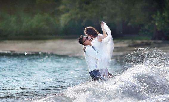 A couple at the beach doing a photoshoot