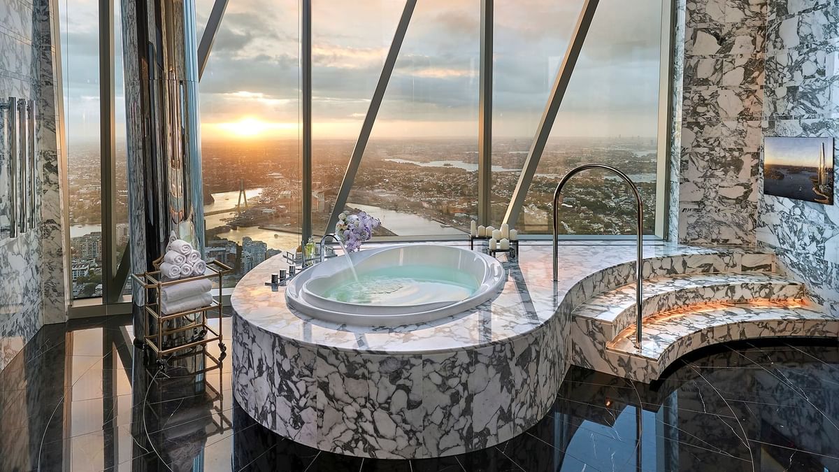 Luxurious marble bathroom with bathtub overlooking a cityscape in Crown Presidential Villa at Crown Hotels