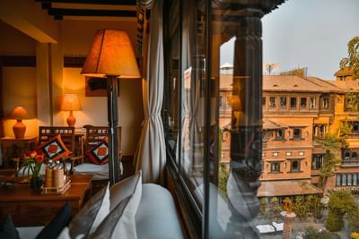 Executive Suite featuring warm lighting, patterned cushions, & a view of a traditional building at Dwarika's Hotel Kathmandu