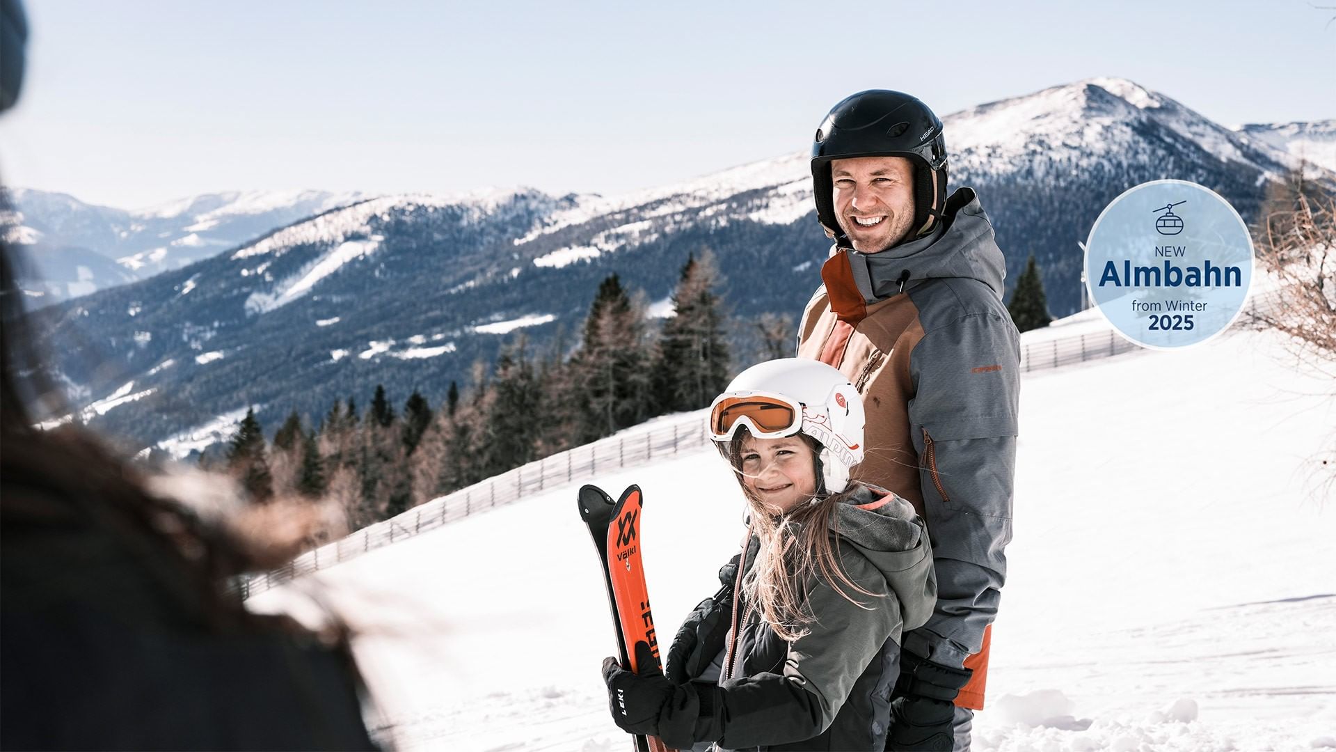 A man and girl with skis in snowy mountains with 