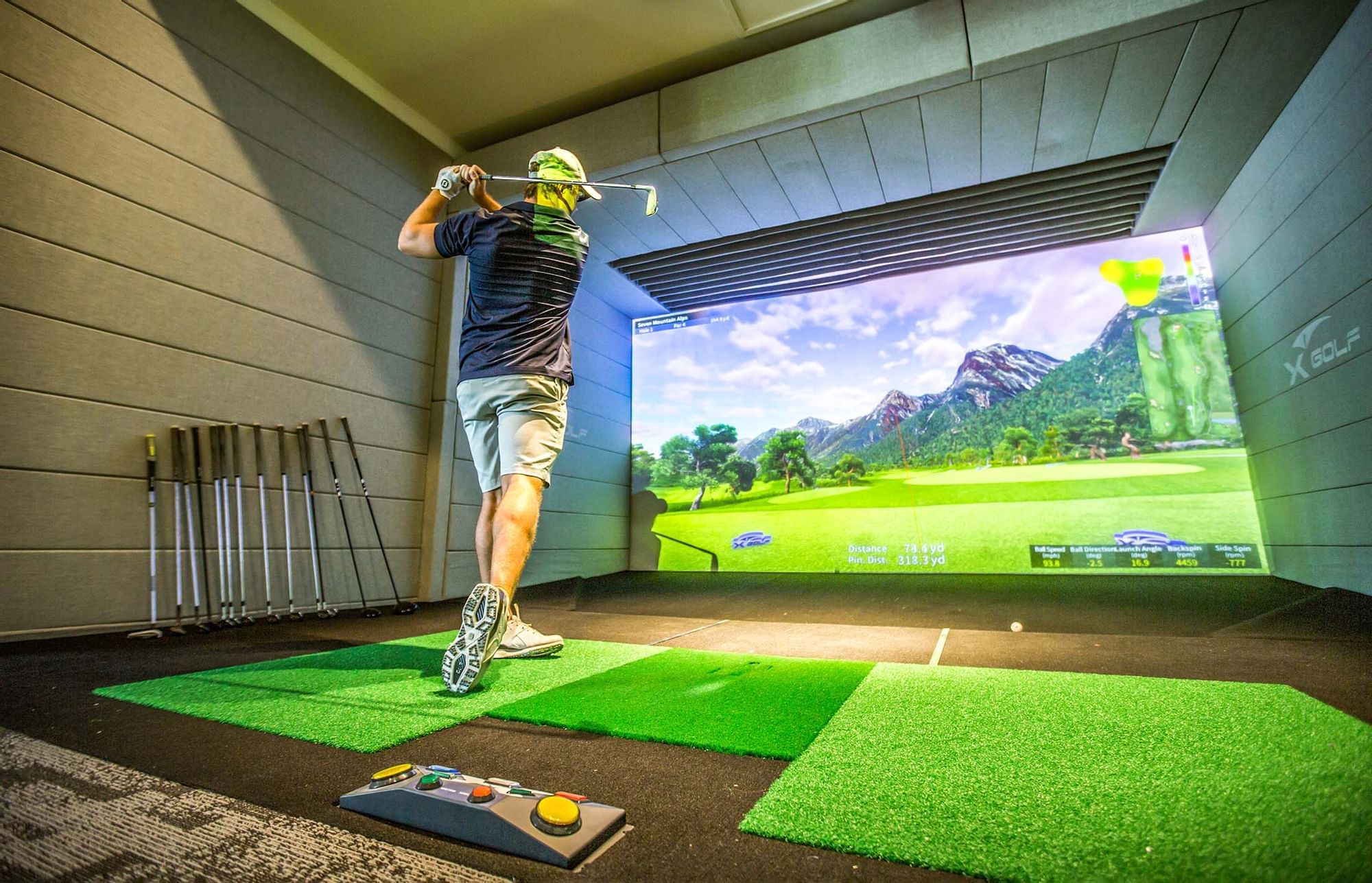 A man playing golf simulator at The Signature Collection