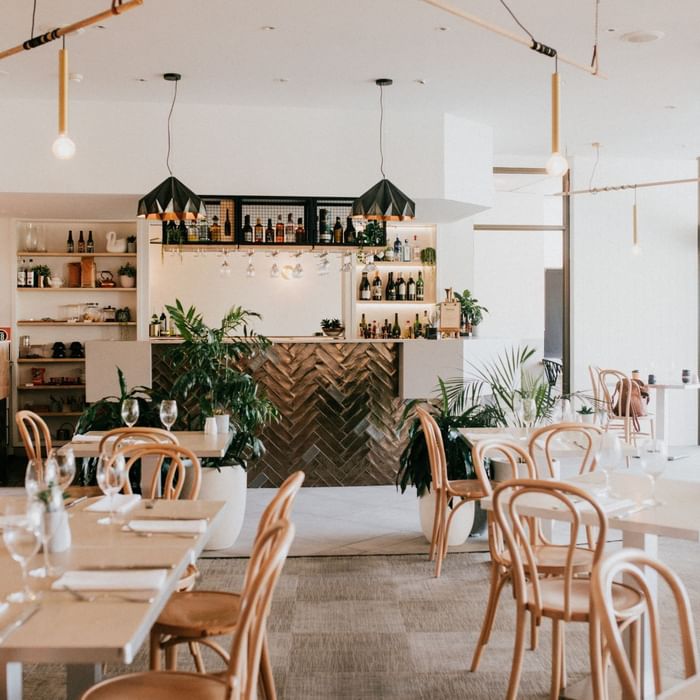 Elegant dining area with set tables and a bar in Mercure Charlestown.